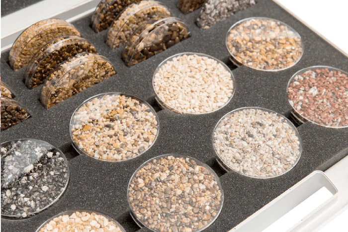 Tray of physical resin aggregate samples in warm, pale and grey colours
